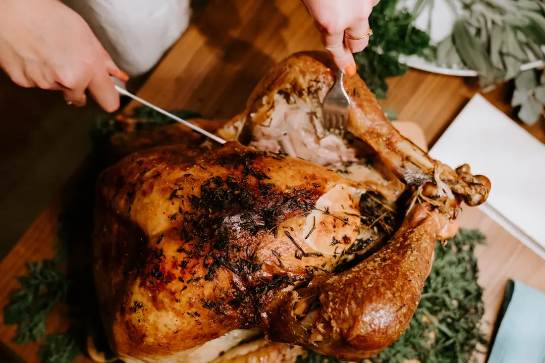 A roast turkey being carved on a board
