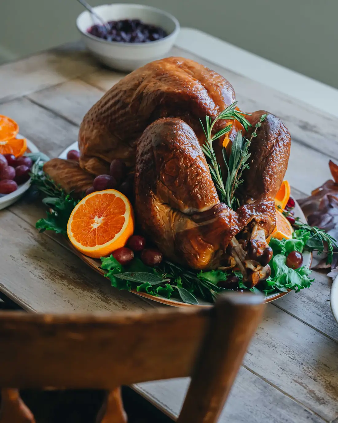 A whole roast turkey garnished with orange halves and herbs